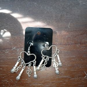 Silver heart-shaped earrings with music notes and microphone.